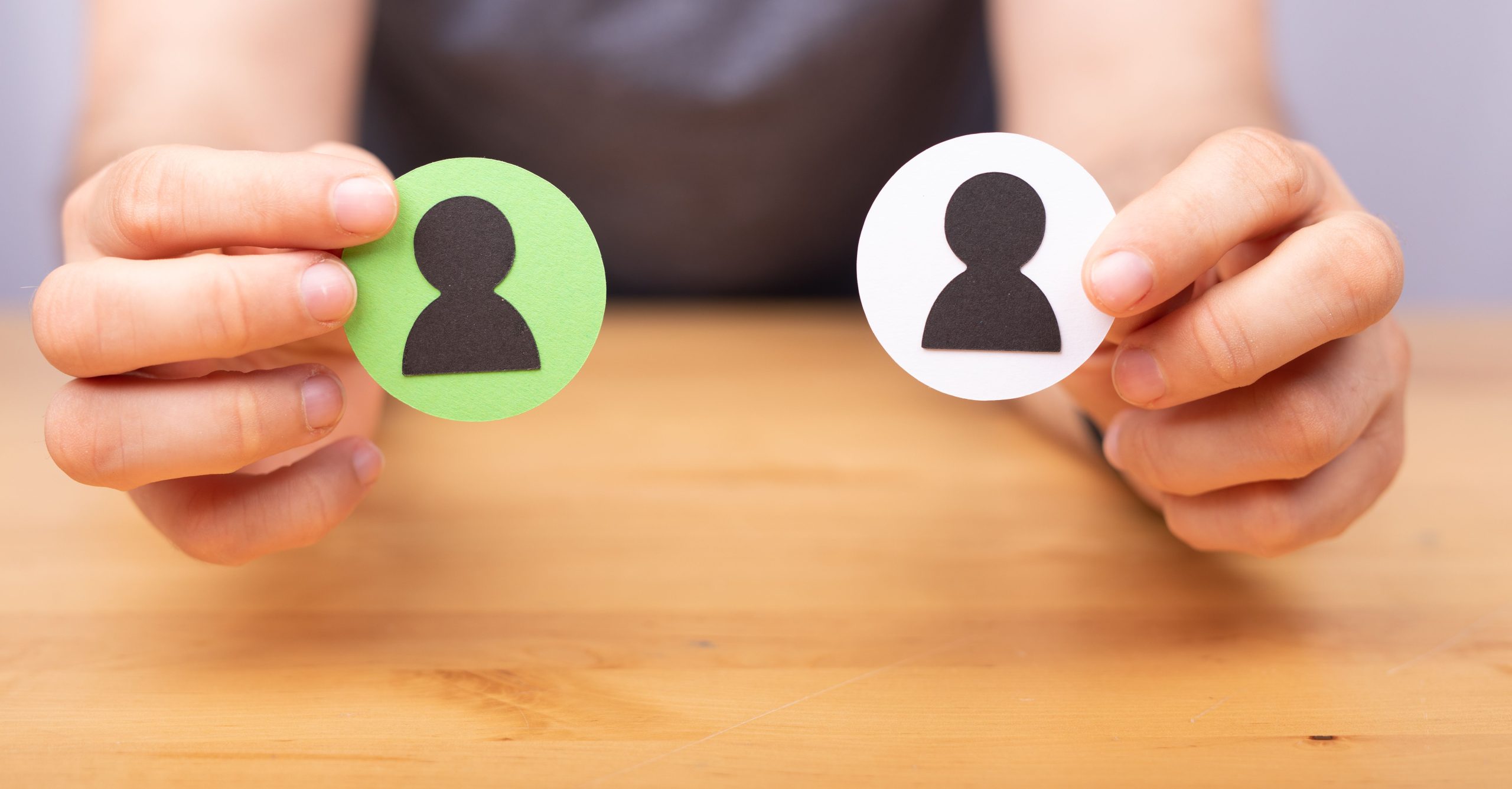 Female hands holding two human icons on wooden office, recruitment employee concept Depending on the actual responsibilities of a role, sometimes a passive candidate with a different job title may still fit.