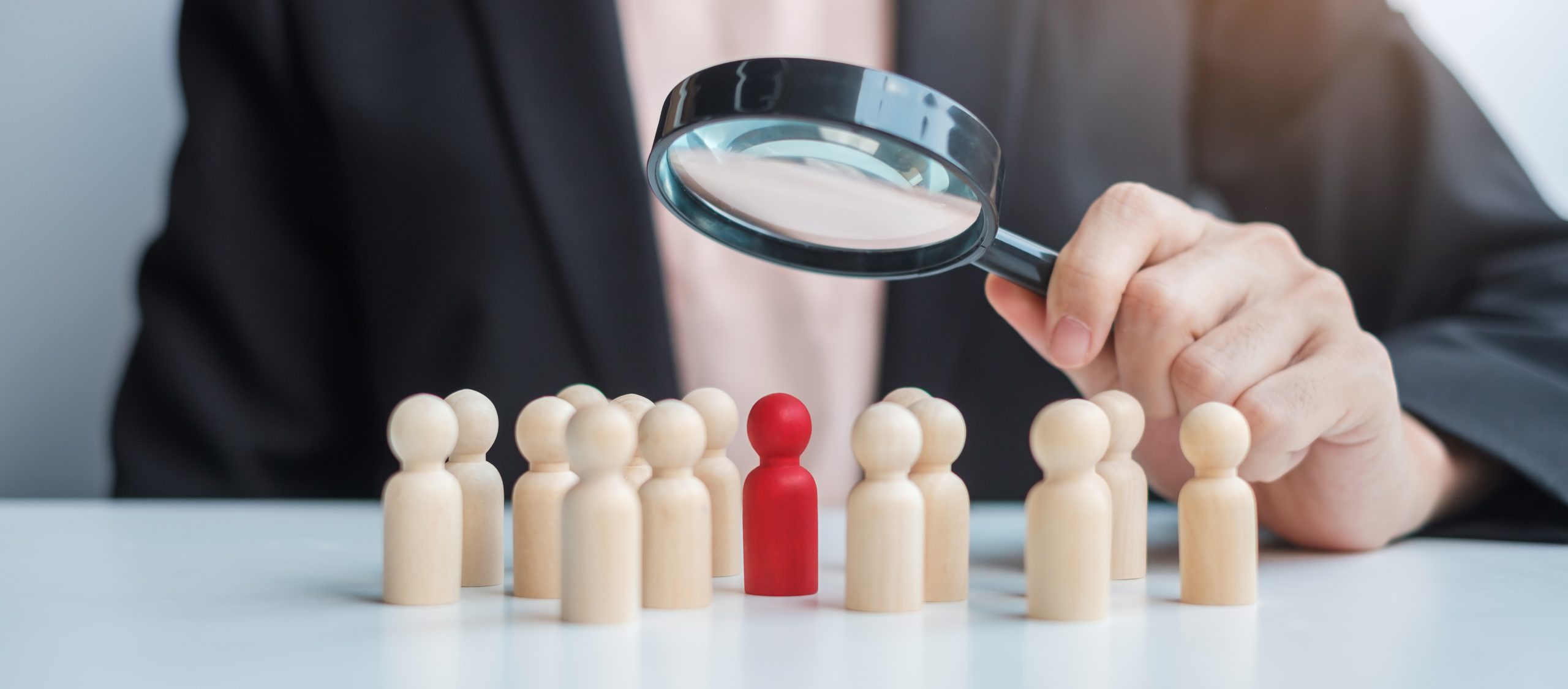 Businesswoman hand holding magnifying glass for recruiting leade Before you begin your search and find your first passive candidate, you need to know exactly what candidate qualities to look for.