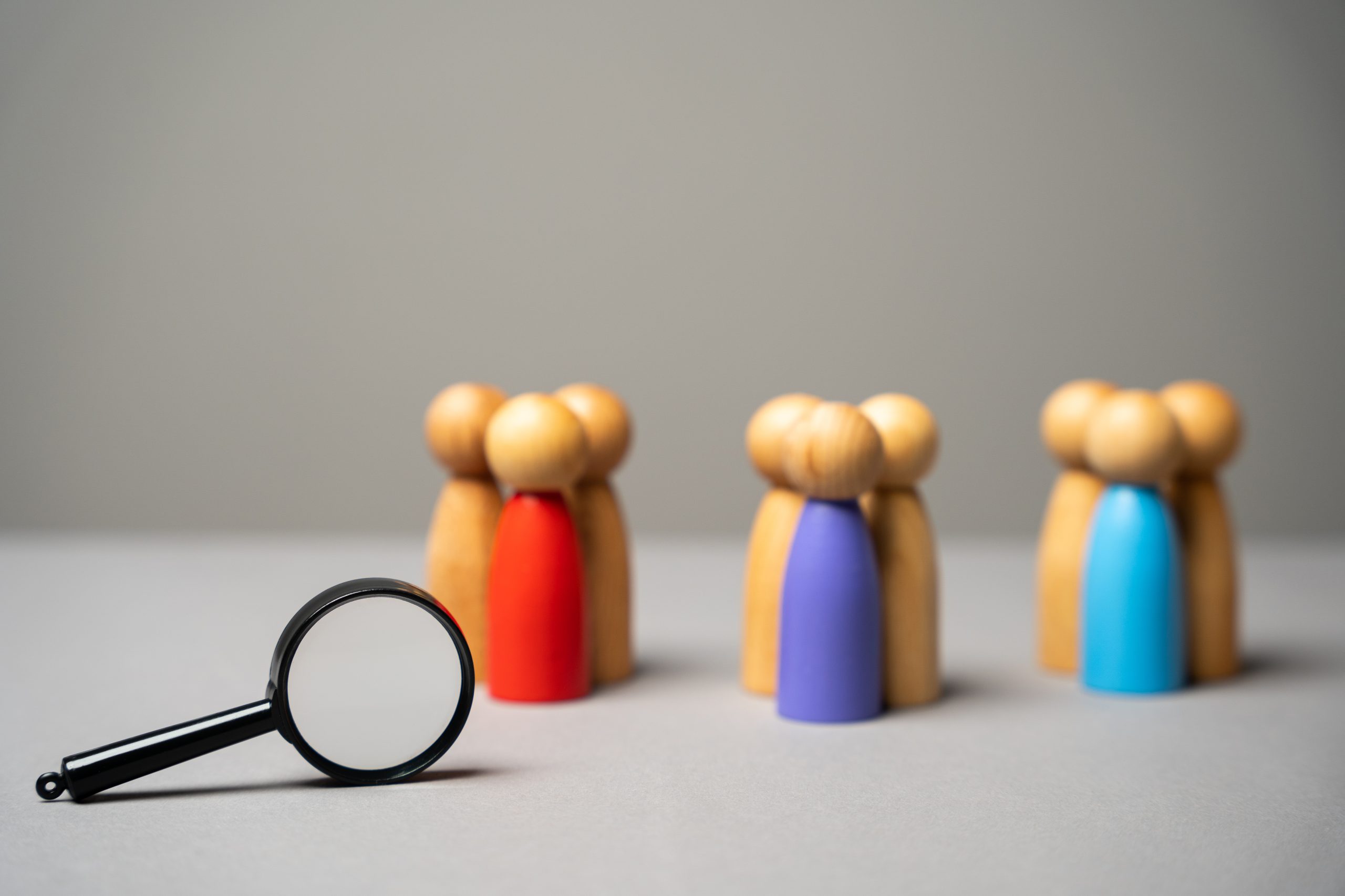 The concept of market segmentation. Target audience, customer care. Market group of buyers. Customer relationship management. Wooden figurines of people and magnifying glass Once you've defined your passive candidate personas and search criteria, you can begin segmenting the passive candidates you source.